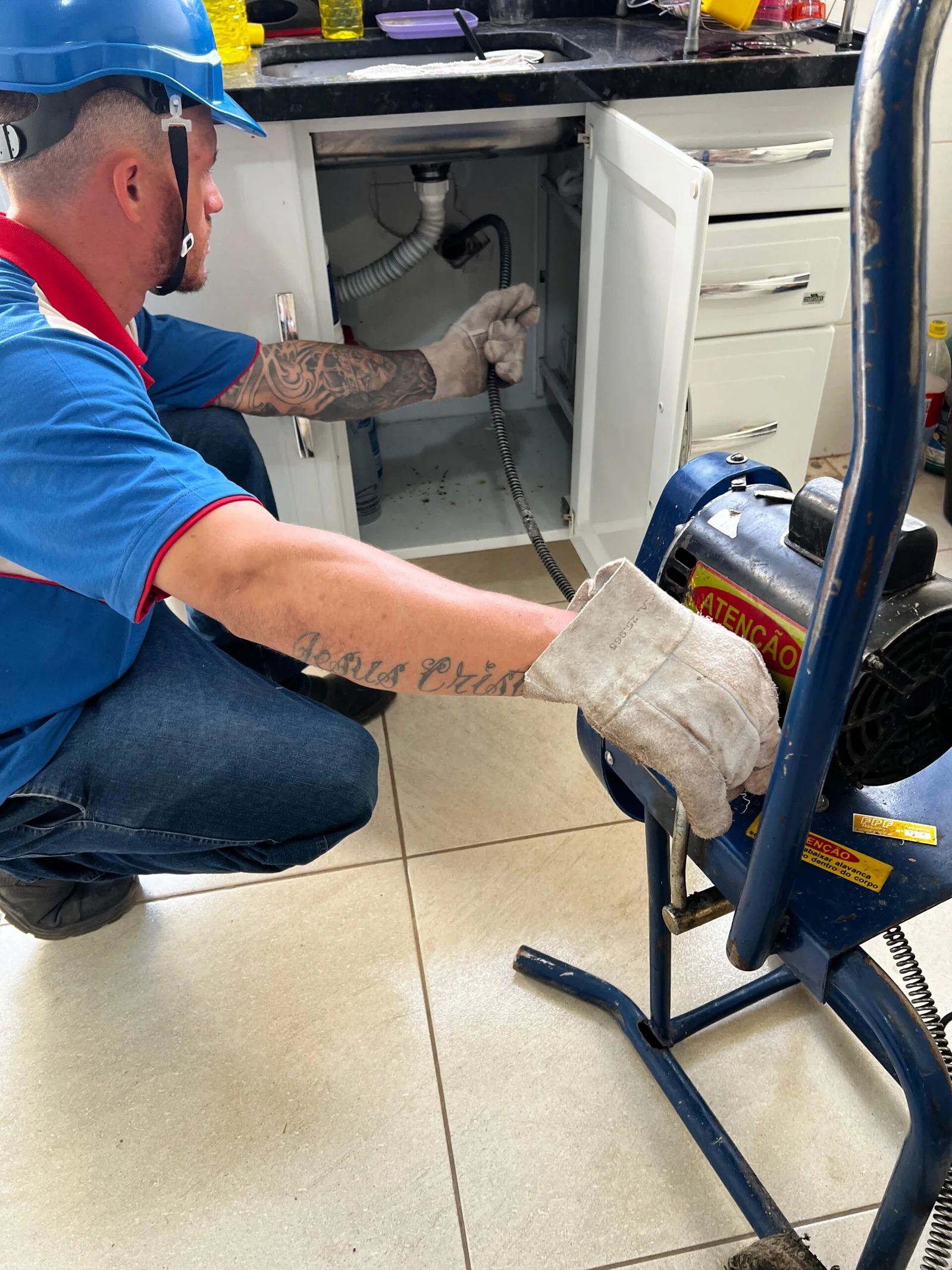 Encanador realizando manutenção em pia e lavatório